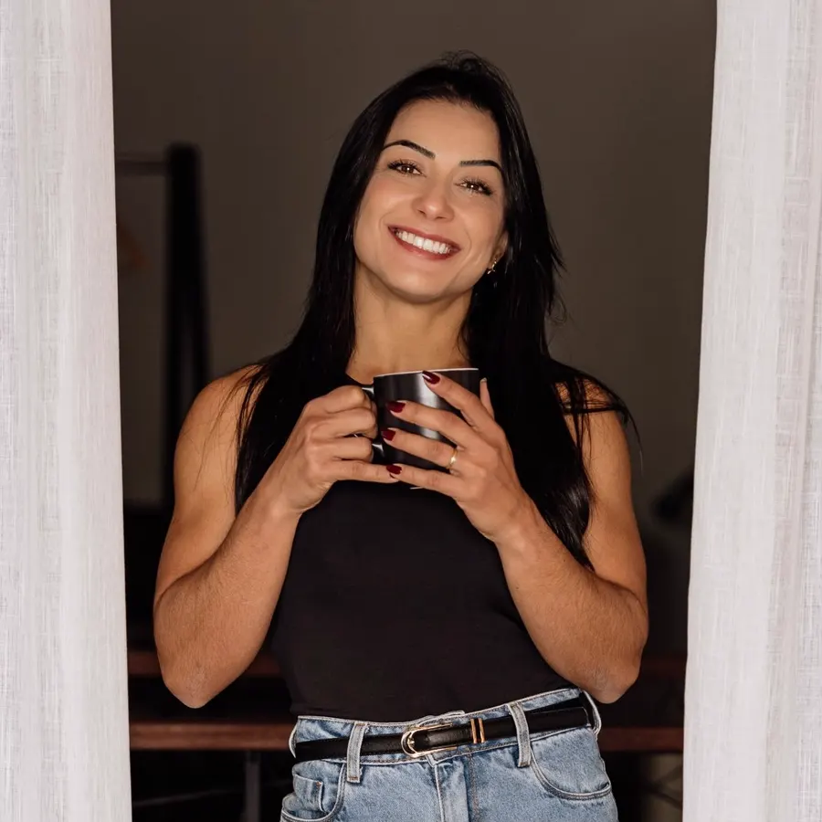 Liz Soca sorrindo, segurando uma xícara